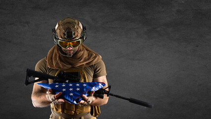 Soldier grieving for the fallen friends - he holding folded American flag.