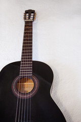 Fototapeta premium Guitarra española negra. Guitarra apoyada en cama. Fondo de guitarra española. Instrumento de cuerda. 