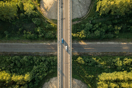 Aerial top down view over highway viaduct via railway. Drone view of bridge with cars over railroad. Crossing railway line and motorway