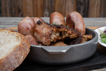 Barbecue. Closeup view of chorizos, pork sausages, grilled gizzards and homemade bread. 