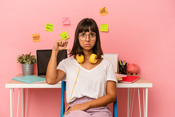 Young mixed race woman preparing a exam in the room listening to music isolated on pink background showing a dislike gesture, thumbs down. Disagreement concept.