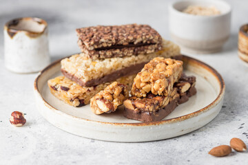 Assortment of different energy protein bars in ceramic plate. Healthy vegan snack. closeup