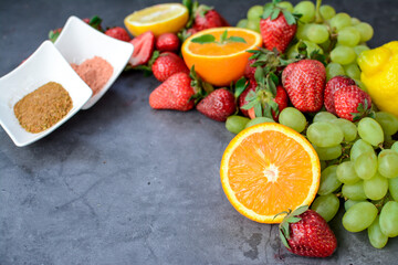 Various fruits and berries on dark stone table