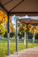 Fototapeta premium Street umbrellas for cafes against the backdrop of greenery and lanterns
