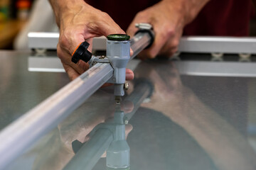 A master in the workshop cuts glass according to the customer's dimensions.
