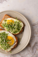 Fried egg sandwich with microgreens.