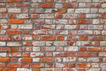  A wall of old red and orange bricks laid horizontally. Texture for the background.