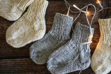 Chunky and warm handmade woolen socks on dark wooden background 