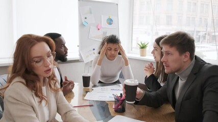 Employees in the office swear over poor business results. The tense situation in the team. Focus on tired woman from stress at work