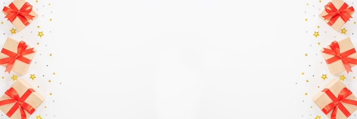Banner with gift boxes, red ribbon, silver and gold stars on a white background. New Year and Christmas card. Flat lay, top view, copy space.