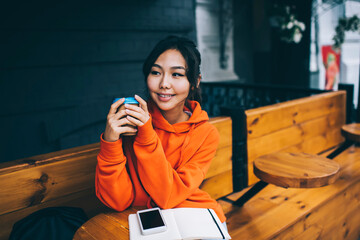 Satisfied Asian woman with paper cup of coffee