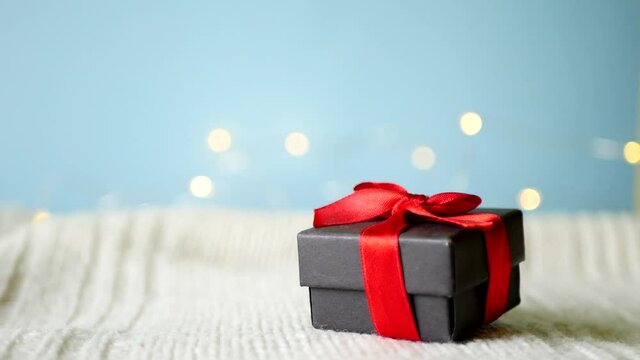 Close up put gift box with red bow. Christmas present giving. Copy space. Holiday celebration 4k video