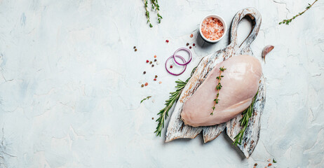 Fresh chicken fillet on cutting board with spices and herbs. Cooking ingredients. Long banner format. top view