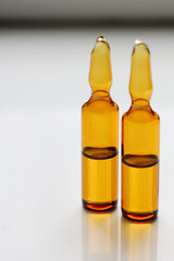 Glass ampoules with medicine or chemical reagent on the table. Medical ampoules close-up. Beauty salon concept.