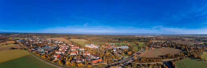 Wide view over the bavarian city Oberhaching in colors of the indian summer as panoramic aerial photo.