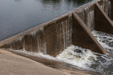 The water flow pass the weir from upper level to lower level.