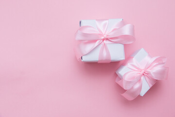 Gift boxes tied with a pink bow. Postcard, top view, flat lay.