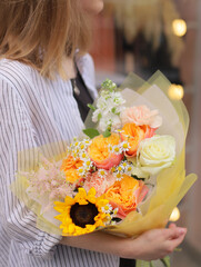 Big stylish flowers bouquet for a gift Women`s Day.  Big beautiful blossoming bouquet of fresh flowers in bright colors wrapped in paper.