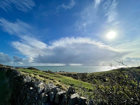 view of the sea with lighthouse and rain clouds