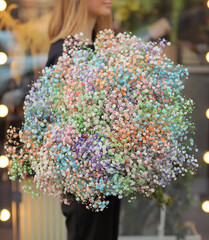 Close up of baby's breath flower (Gypsophila) bouquet. Woman holding big and beautiful mono bouquet of colorful dyed gypsophila