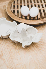 eggs and paperboard egg box on rustic wooden background with space for text