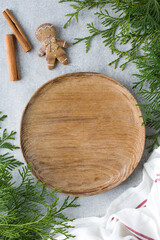 Biscuit cinnamon and wooden plate lie on table sprinkled with snow and decorated