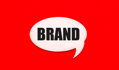 On a bright red background, a light wooden curly card with a dough BRAND