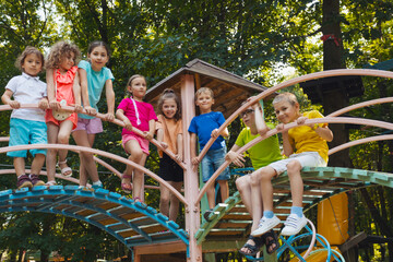 The little kids stand on a bridge in the playground