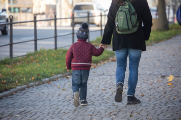 A boy with his mother walks down the street by the hand © Taras
