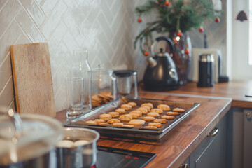 Homemade Christmas cookies on a baking sheet on a wooden table.