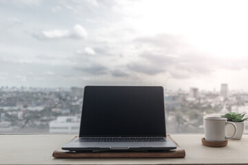 Laptop computer on the wooden bar at the balcony of the apartment.