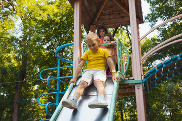 The happy little kids about to slide in the playground