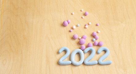 blue numbers 2022 made of plasticine on a wooden background and balls