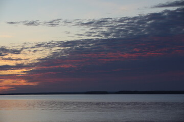 Obraz premium Sunset sky with picturesque purple clouds over the water