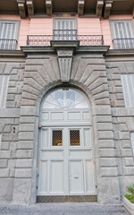 vintage building arched entrance grey painted door, Rome Italy