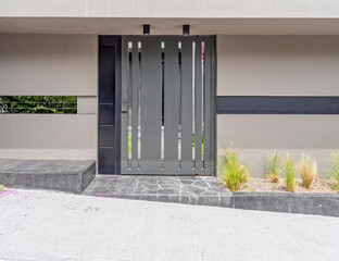 modern house entrance metallic door by the sidewalk