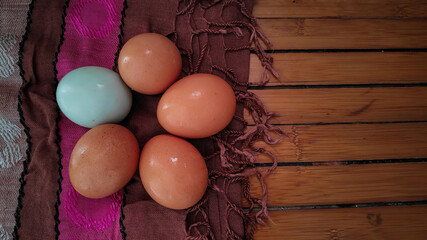 some eggs on a wooden table with a tablecloth