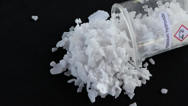 Potassium hydroxide flake on black background, chemistry in the laboratory