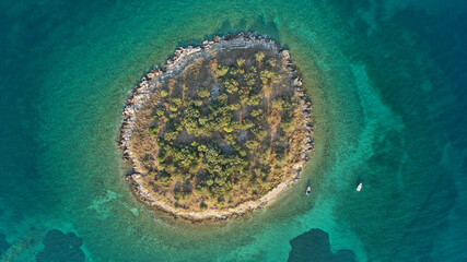 Aerial drone top down photo of small tropical exotic island covered in  limestone with emerald sea