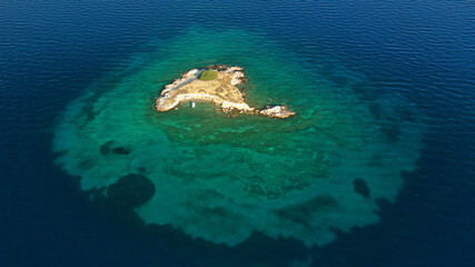 Aerial drone top down photo of small tropical exotic island covered in  limestone with emerald sea
