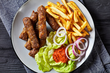 cevapcici with potato fries, lettuce, onion, ajvar