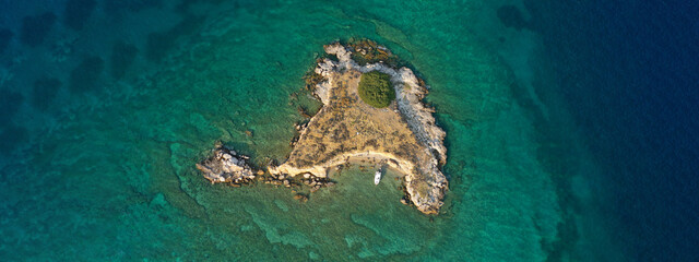Aerial drone top down photo of small tropical exotic island covered in  limestone with emerald sea
