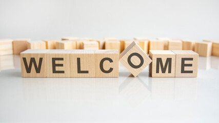 welcome text on a wooden blocks, gray background.