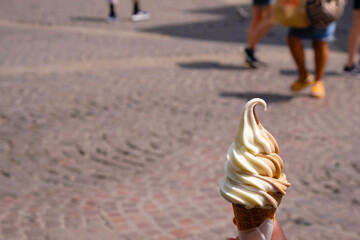 Coconut caramel ice cream just melting from the summer heat on Avignon cobblestones background.