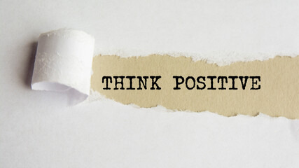 think positive. words. text on grey paper on torn paper background