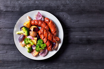 Sausage, broccoli, potato on a plate, copy space