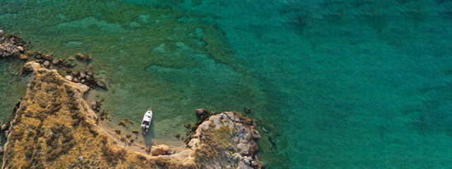 Aerial drone top down photo of small tropical exotic island covered in  limestone with emerald sea © aerial-drone