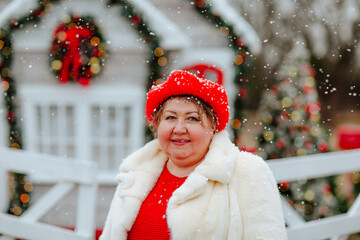 Portrait of adult positive woman against Christmas house