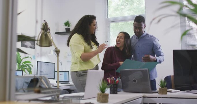 Happy diverse group of business people working together, discussing work in modern office