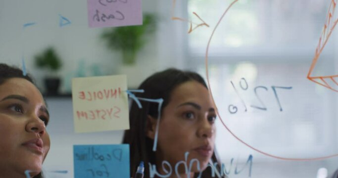 Focused diverse group of business people working together, brainstorming in modern office